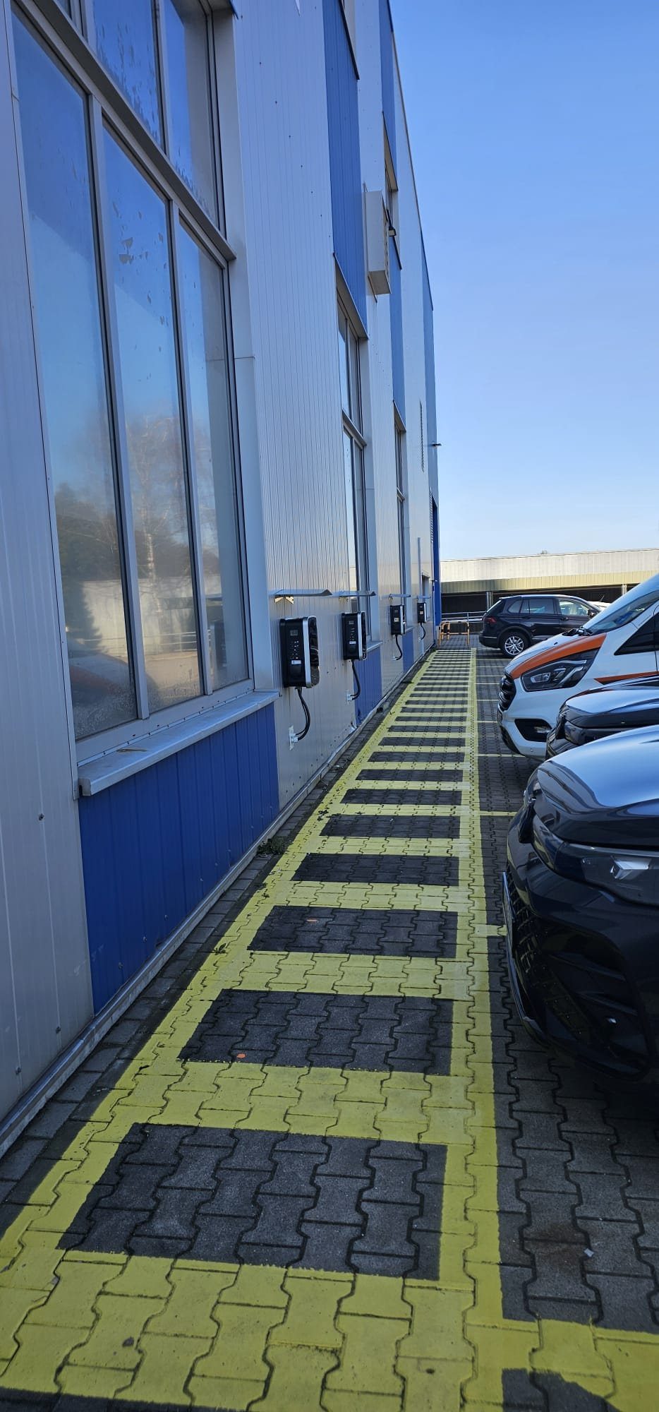 Reihe von Wallboxen an der Fassade eines Gewerbeobjekts im Kreis Olpe, installiert von Elektrotechnik Kühr